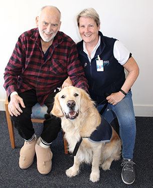Hollywood Private Hospital patient Ian Goldfinch with volunteer Emmy Poulsen and golden retriever Henry.